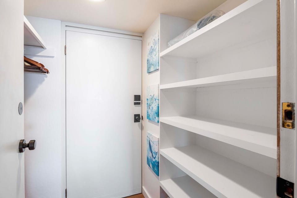 Walk-in closet with hangers and plenty of available shelf storage.