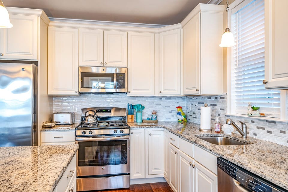 This modern kitchen features granite countertops and stainless steel appliances