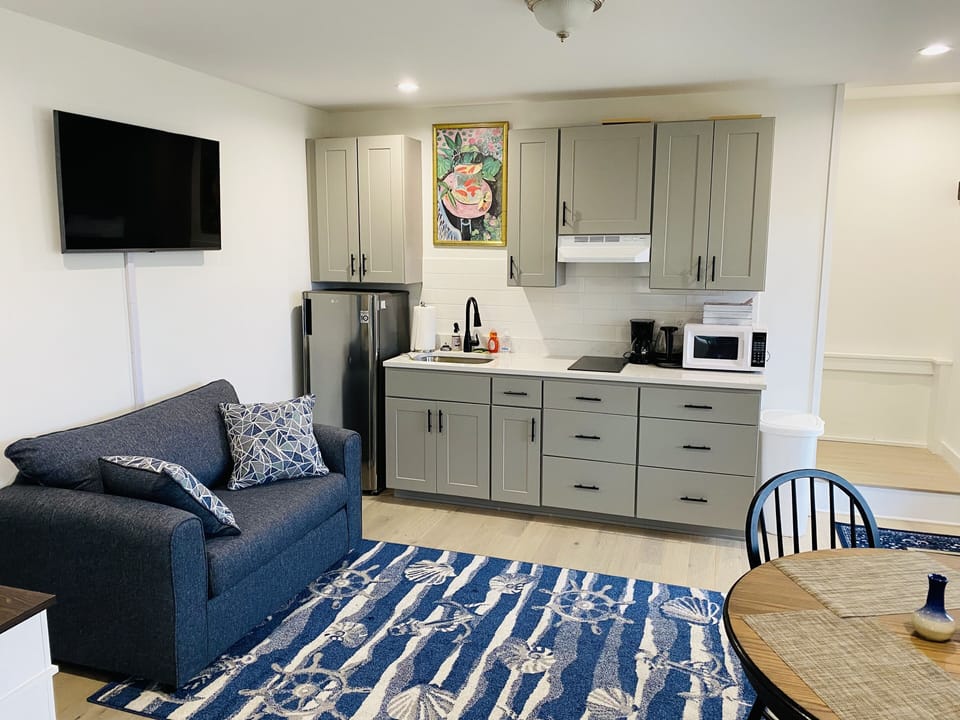 kitchenette with electric stove top, fridge, microwave, kettle, espresso machine