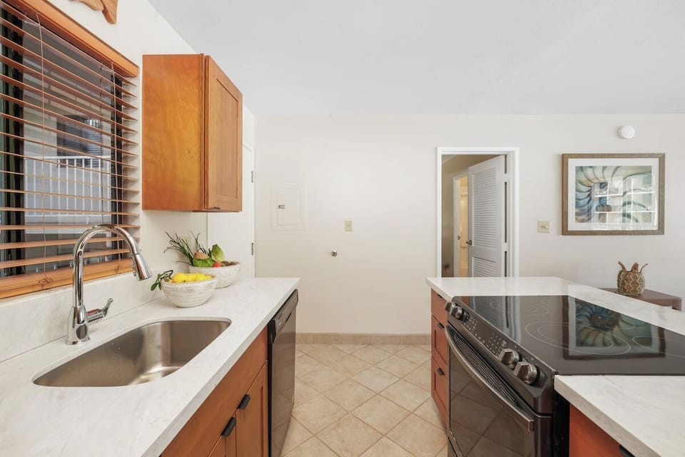 Bright kitchen with extended view — sink area, window light, and connection to living space.