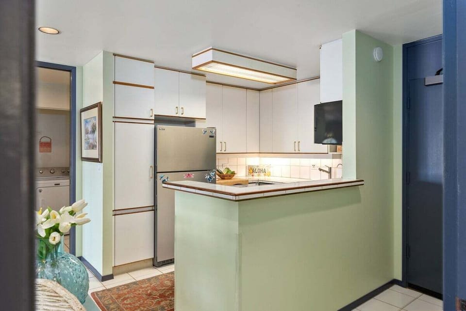 Functional kitchen with stainless steel appliance and white cabinets