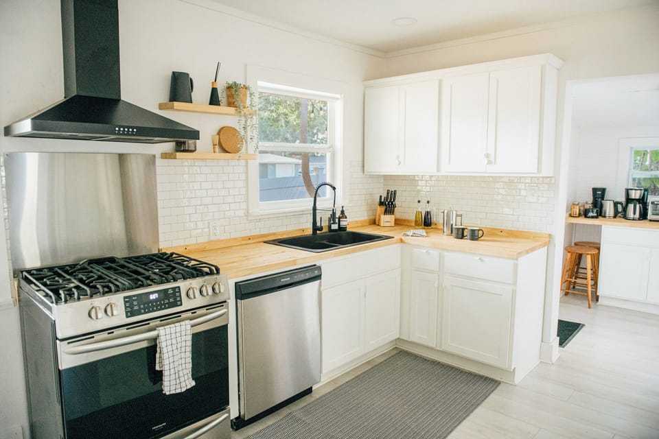 Newly renovated (2023), fully stocked kitchen with dishwasher, farmhouse sink and double-door fridge. The open-concept layout offers a seamless flow between the kitchen, dining, and living area.