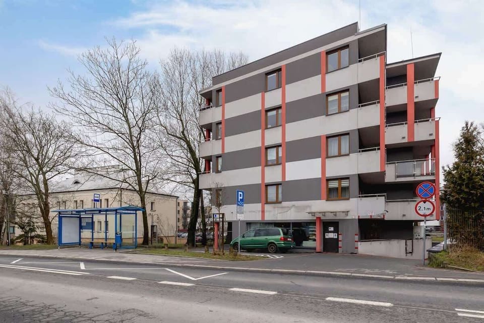 An exterior view of the apartment building, showing a modern facade with balconies and large windows.

