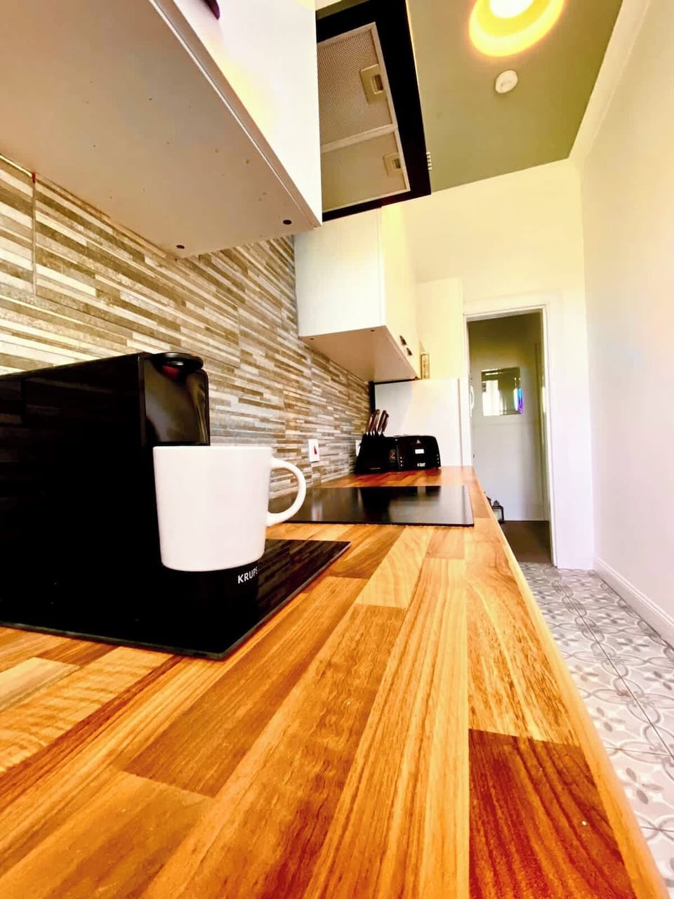 Kitchen: a cooking space equipped with utensils, washing machine, pots and pans.