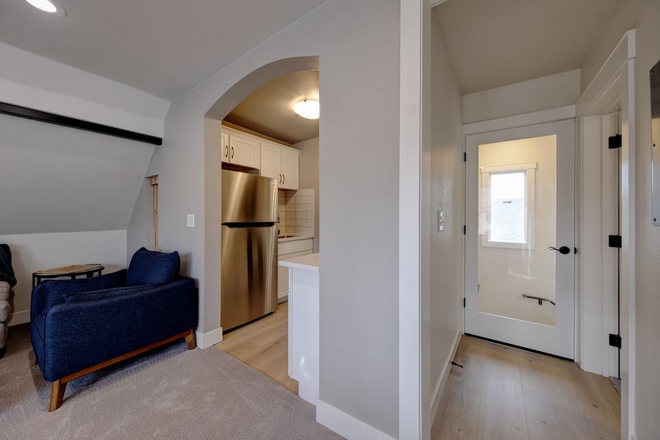 Showing hallway to the bedroom on the right. Door to the stairs straight ahead.