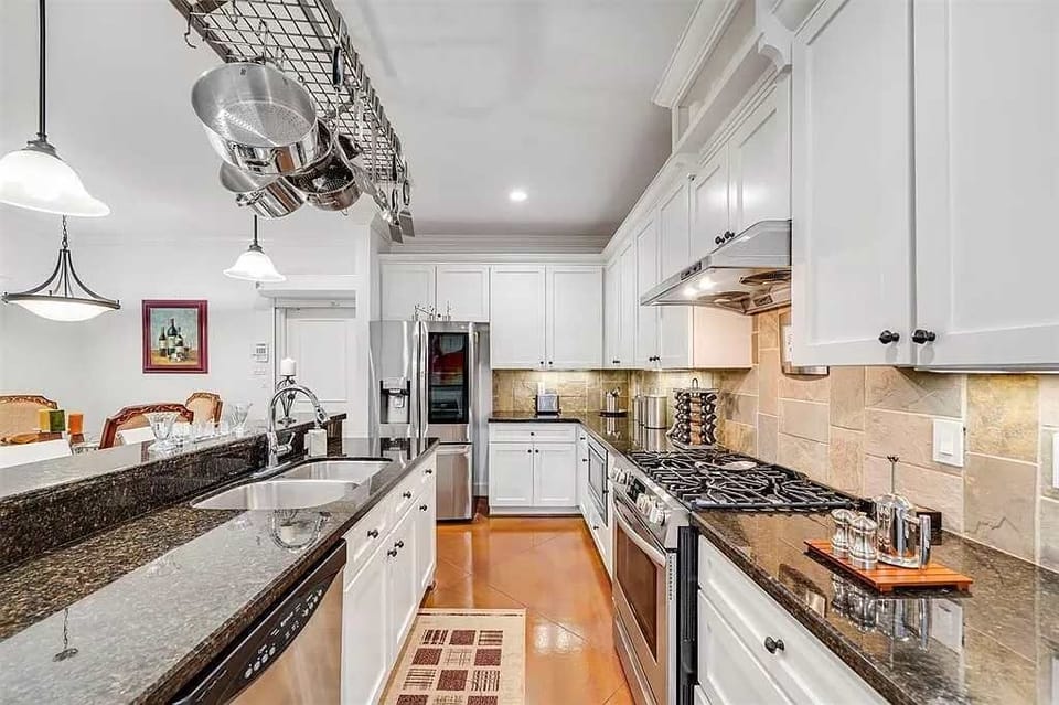 Modern kitchen with gas stove, cookware, and spacious counters for meal preparation.