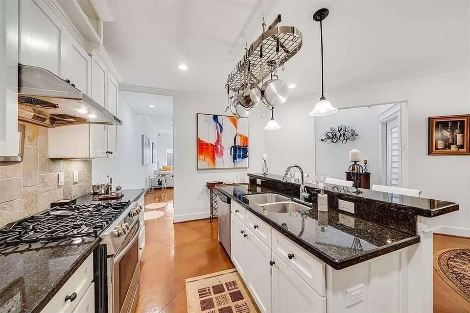 Fully equipped kitchen with stainless steel appliances and large island.