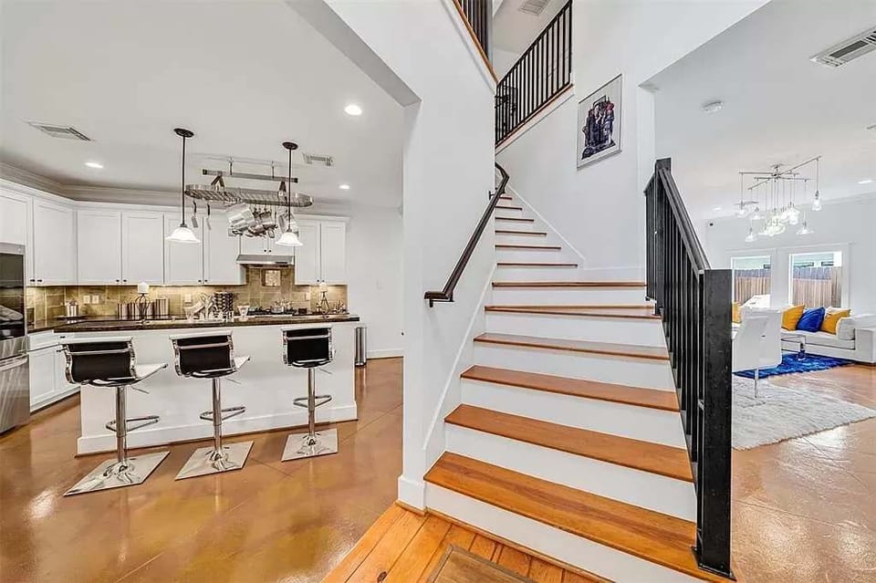 Bright entryway with staircase and open layout connecting the kitchen, dining area, and living room.