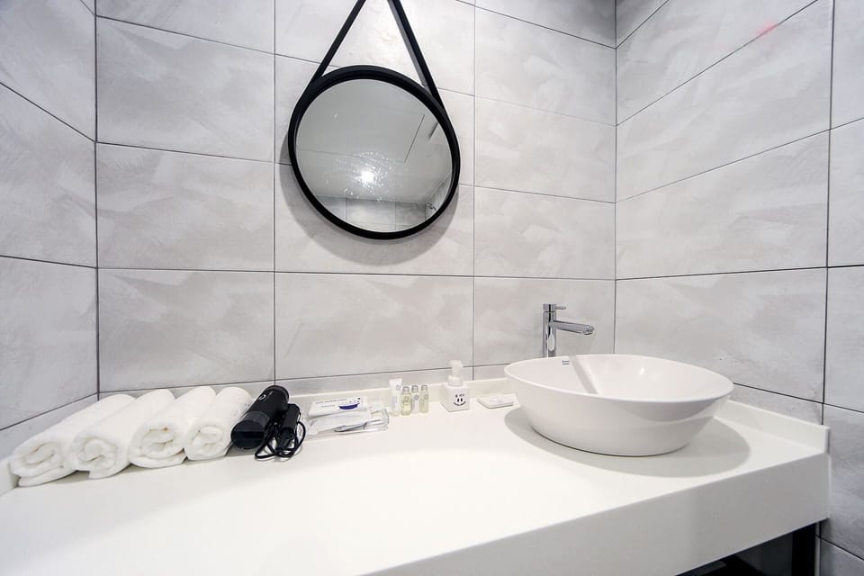 Deluxe Room | Bathroom | Combined shower/tub, designer toiletries, hair dryer, slippers