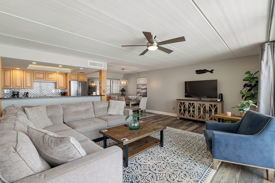 Living room area with big screen tv and kitchen 
