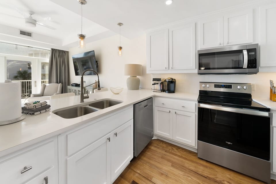Your gleaming white kitchen features modern appliances and spacious counters, perfect for preparing memorable vacation meals together.