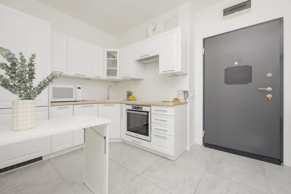 A different view of the kitchen, capturing the entrance, tiled flooring, and a seamless, modern aesthetic.

