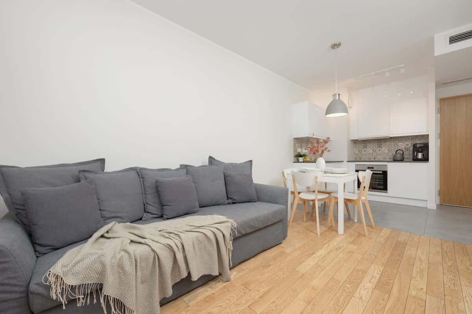Bright living room with fully equipped kitchenette and dining area.