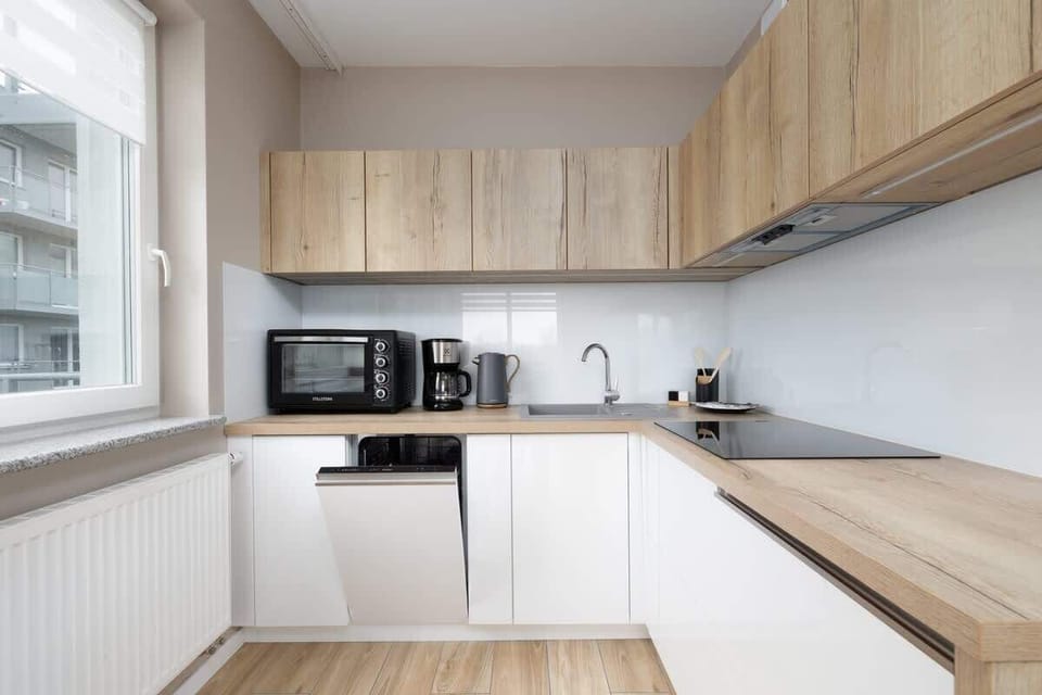 Another perspective of the kitchen, emphasizing the natural wood and white color combination, creating a warm and modern aesthetic.

