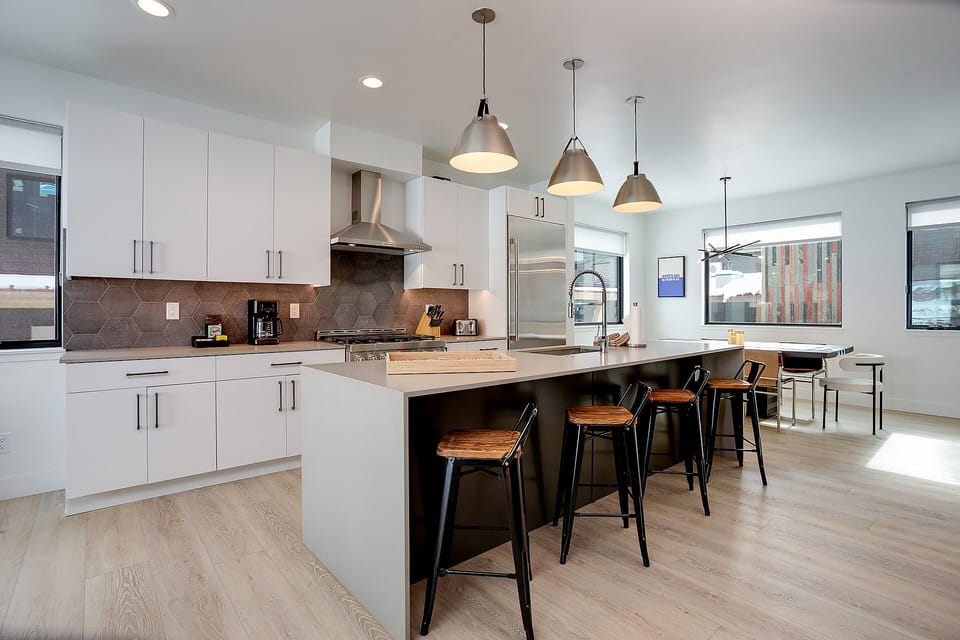 Your modern kitchen features sleek white cabinets, quartz countertops, and a spacious island perfect for morning coffee or evening meals together.