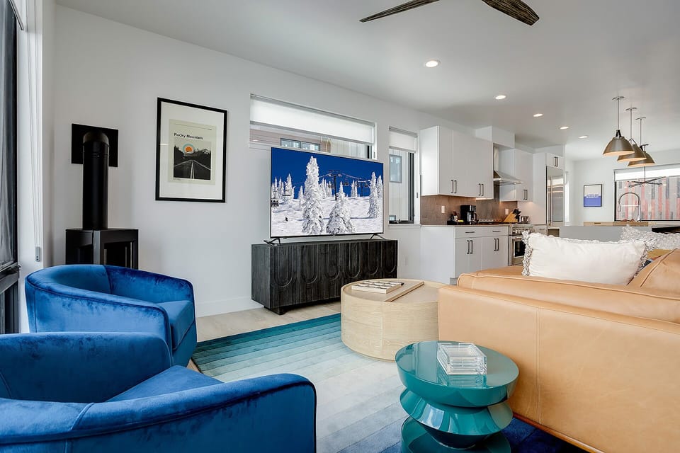 Sink into luxury in your open-plan living space, where modern elegance meets cozy comfort with plush seating and a fully equipped kitchen.