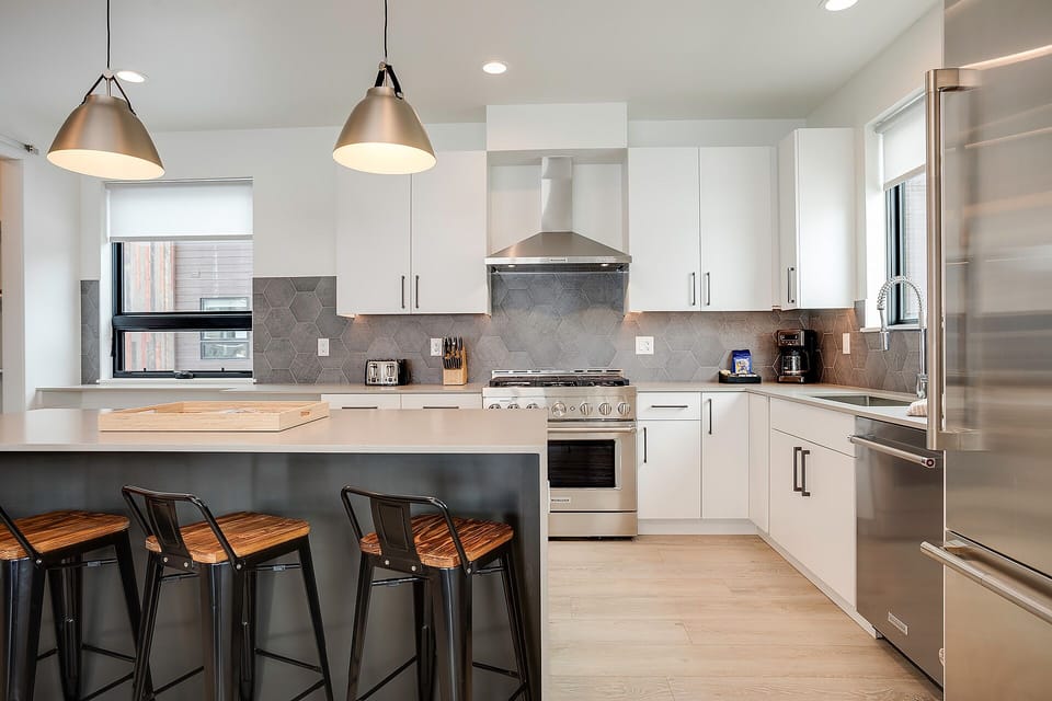 Your sleek modern kitchen awaits with stainless steel appliances, granite countertops, and a breakfast bar for morning coffee.