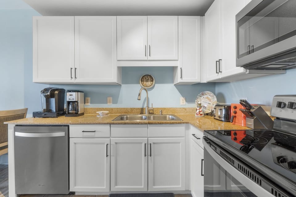 Modern kitchen with white cabinetry and stainless steel appliances