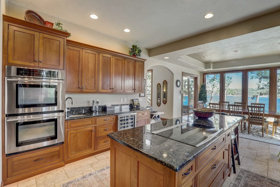 Spacious chef’s kitchen with granite countertops, stainless steel appliances, and large island, perfect for cooking and entertaining.