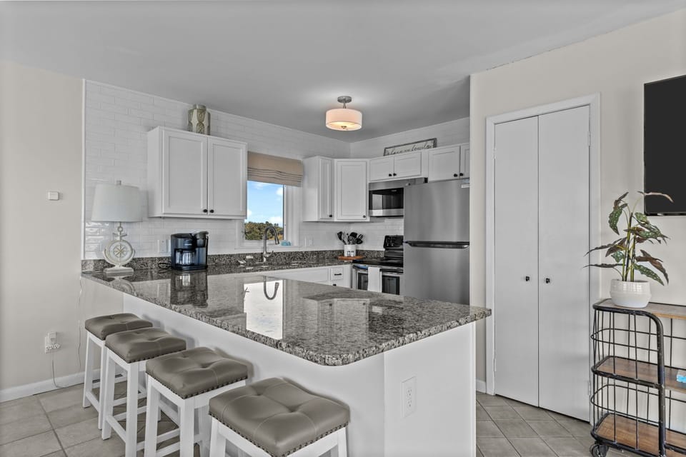 Your fully equipped kitchen features granite countertops, stainless steel appliances, and a breakfast bar perfect for morning coffee or casual meals.