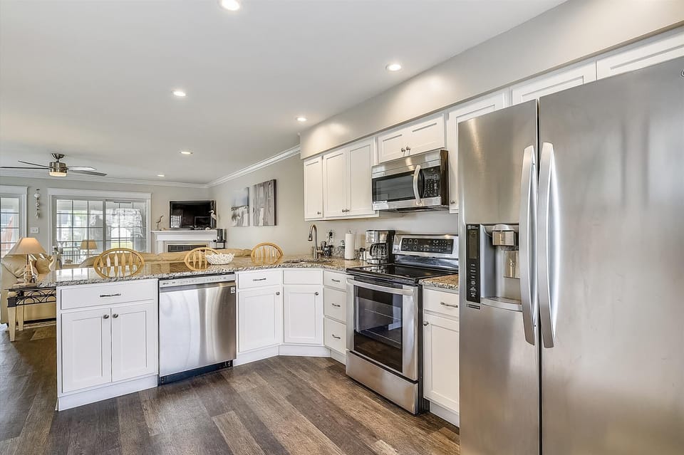 You'll love preparing meals in this bright, fully equipped kitchen with stainless steel appliances, granite countertops, and plenty of storage. The open layout flows seamlessly into the dining and living areas.