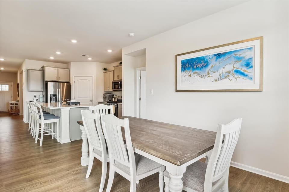 Gather around this spacious dining table or settle into the breakfast bar while your chef whips up coastal favorites in the fully-equipped kitchen—you'll love how effortlessly the open layout brings everyone together.