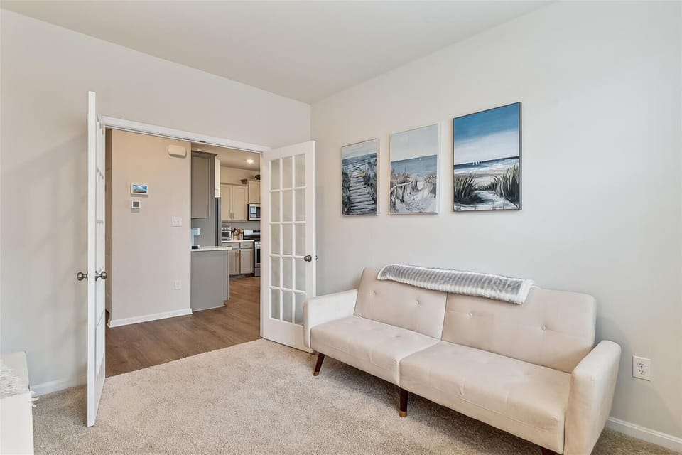 Relax in your private living space featuring coastal artwork that sets the tone for your beach getaway. Through the French doors, discover a well-appointed kitchen ready for your use.