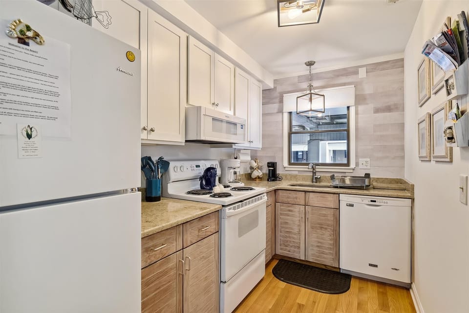 Your fully equipped kitchen features modern appliances, ample counter space, and everything you need to prepare meals during your stay. Warm wood tones and natural light create a welcoming space.