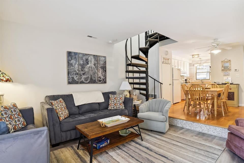 Relax in your spacious living room with coastal-inspired décor, a spiral staircase to added space, and an inviting dining area perfect for meals together.