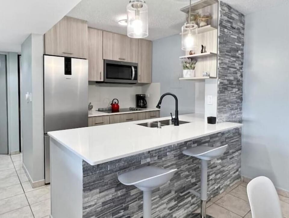 Beautifully redesigned kitchen. Quartz tops, sleek stovetop, microwave, fridge