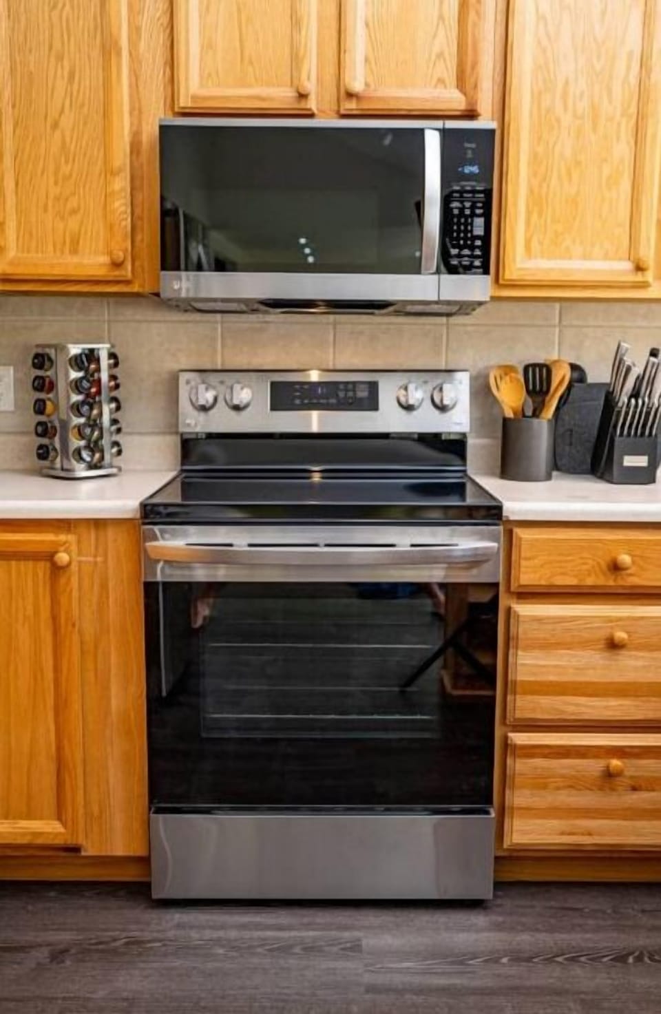 Stainless steel electric range and microwave along w/ cooking and baking pans. 