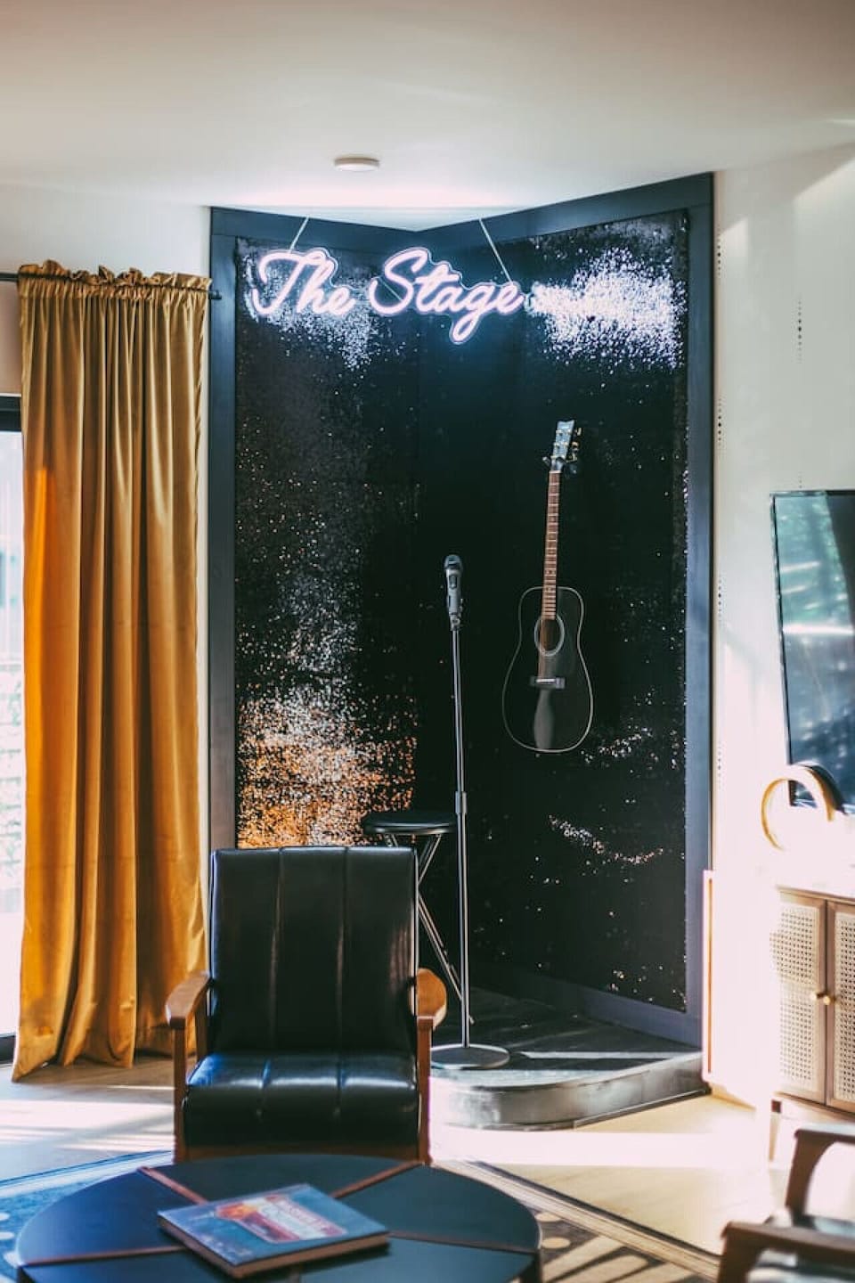 Custom-built stage with sequin fabric covering the walls, an acoustic guitar, & microphone stand!