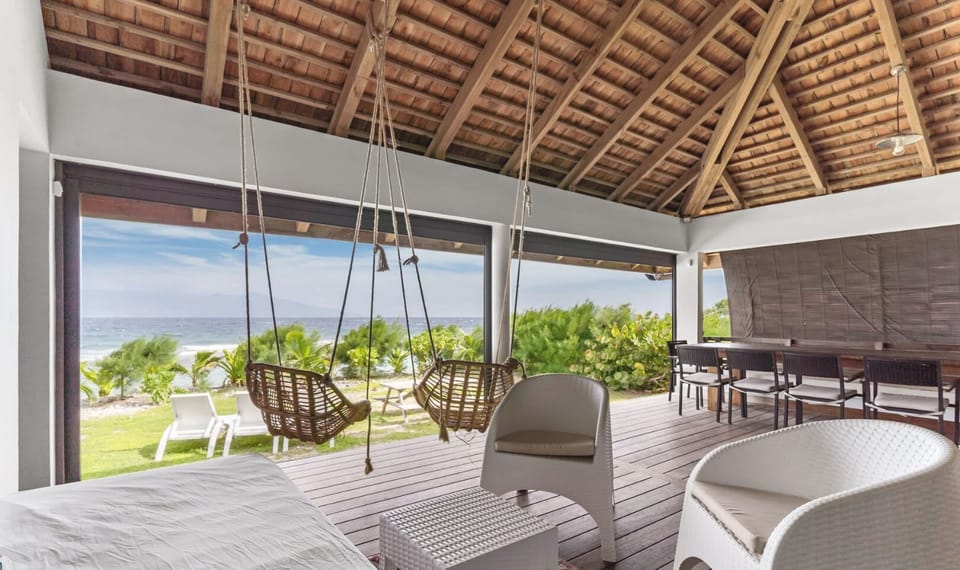 Bright lounge area with ocean and greenery views.