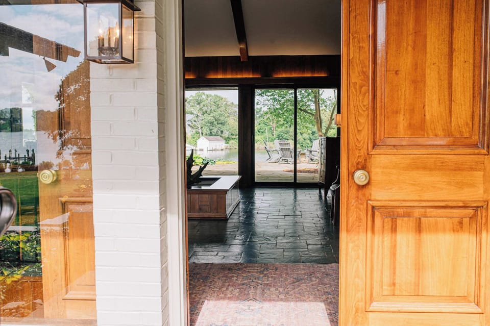 Floor to ceiling windows let the light in on both sides of the expansive entry way. Views out to the water on the other side beckon you. Stairs down to the lower level from here.
