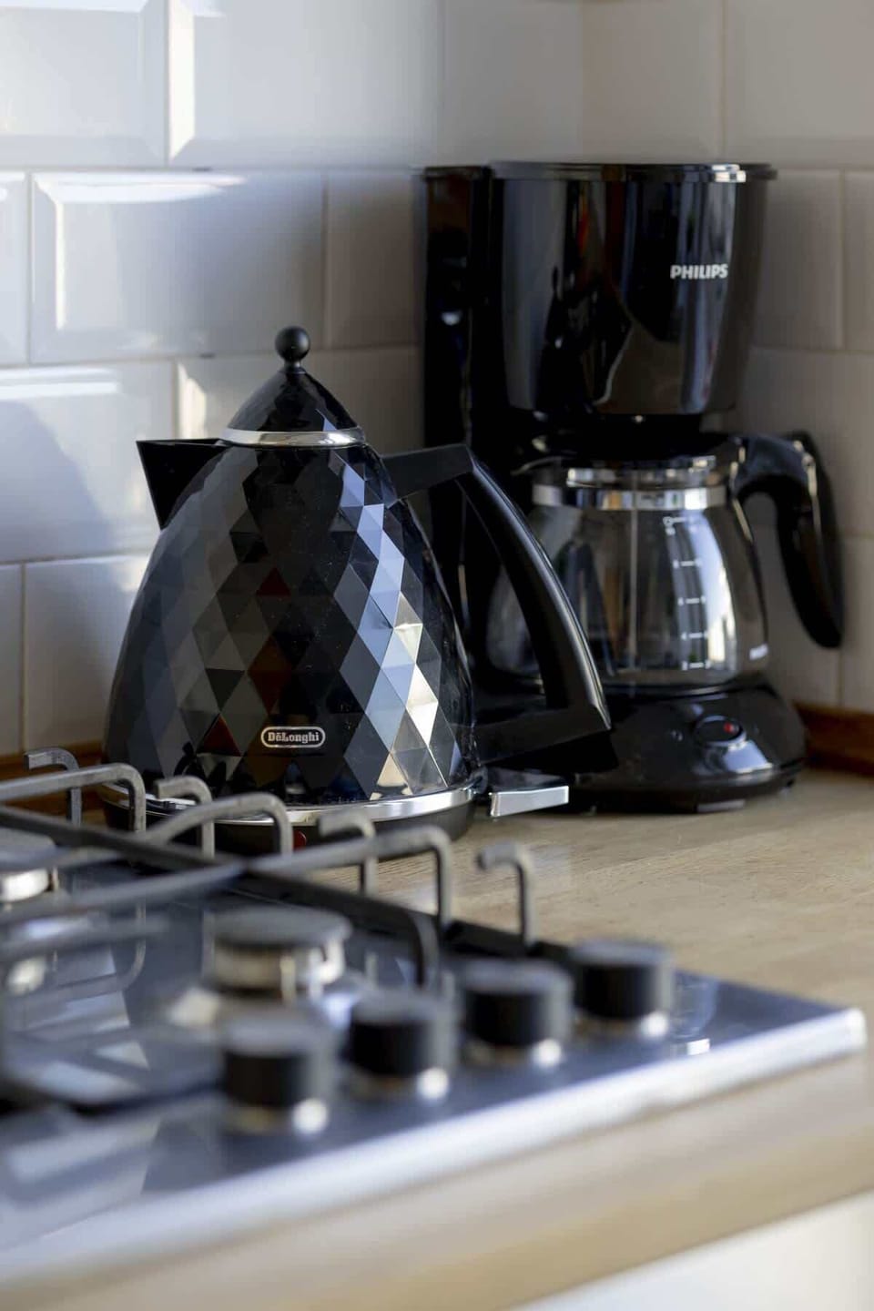 A close-up of kitchen appliances, including a sleek black kettle and toaster, adding functionality and a contemporary touch.

