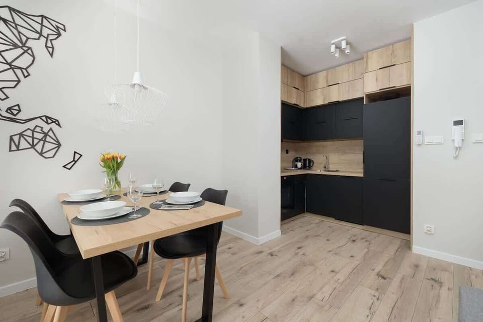 A functional dining and kitchen area, with a well-balanced combination of dark cabinetry, wooden textures, and modern lighting.

