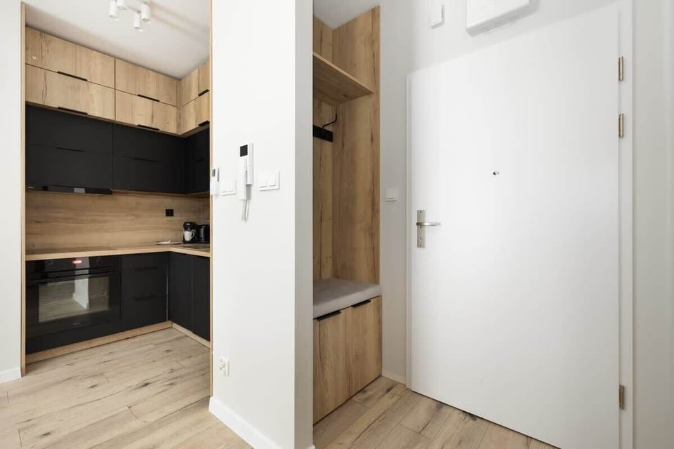 A built-in wooden shelving unit near the entrance, providing storage and a clean, minimalist aesthetic.

