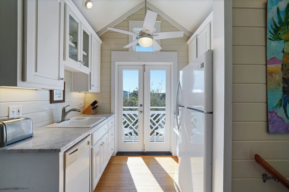 FULLY EQUIPPED KITCHEN WITH GLASS DOORS OPENING TO BALCONY