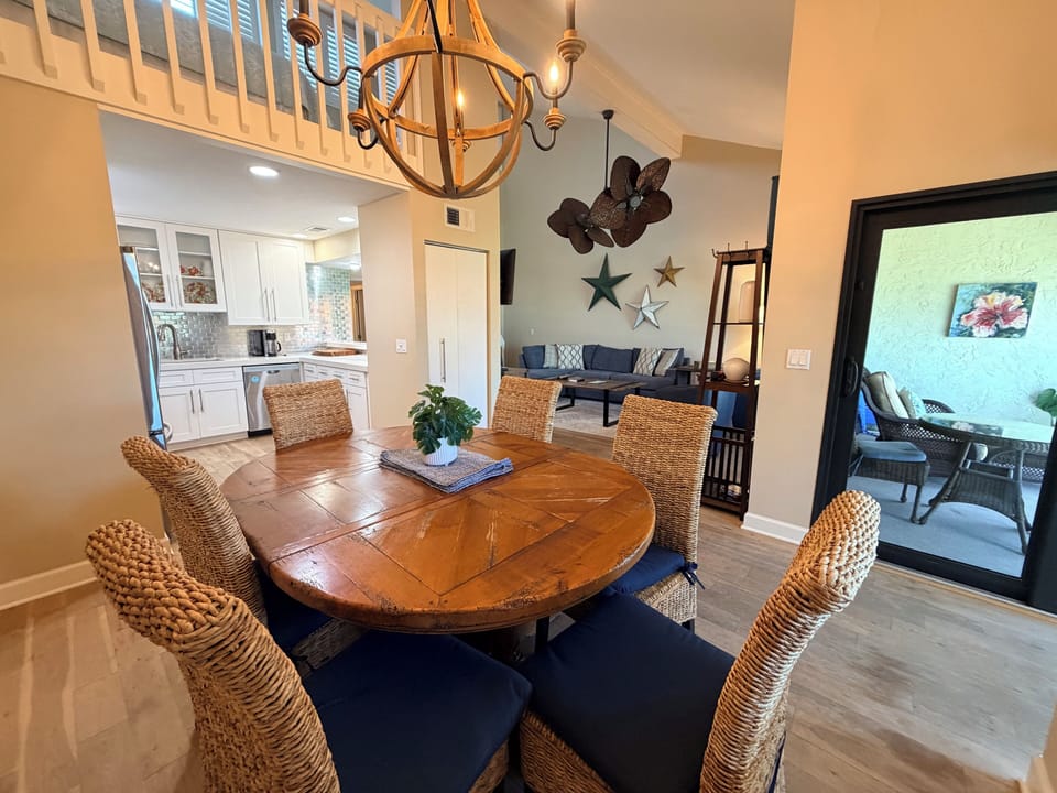 Gather around a stunning round table in your open dining area, where coastal charm meets modern comfort. High ceilings, stylish décor, and seamless flow to the kitchen and living spaces create the perfect retreat.
