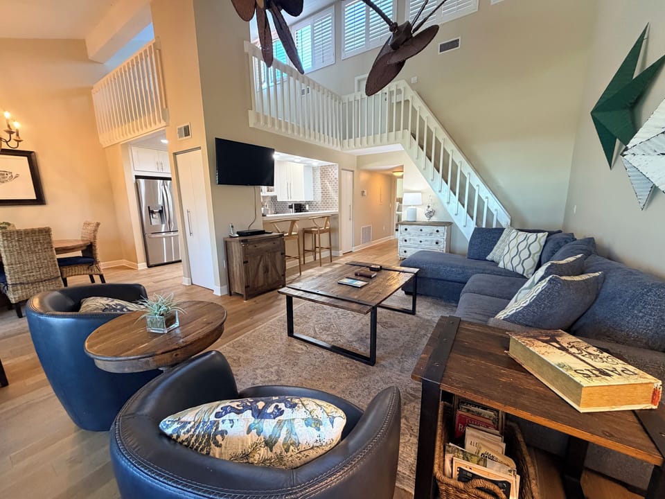 Unwind in your spacious living area with vaulted ceilings, coastal-inspired decor, and thoughtful touches throughout, perfect for gathering after a day exploring nearby attractions.