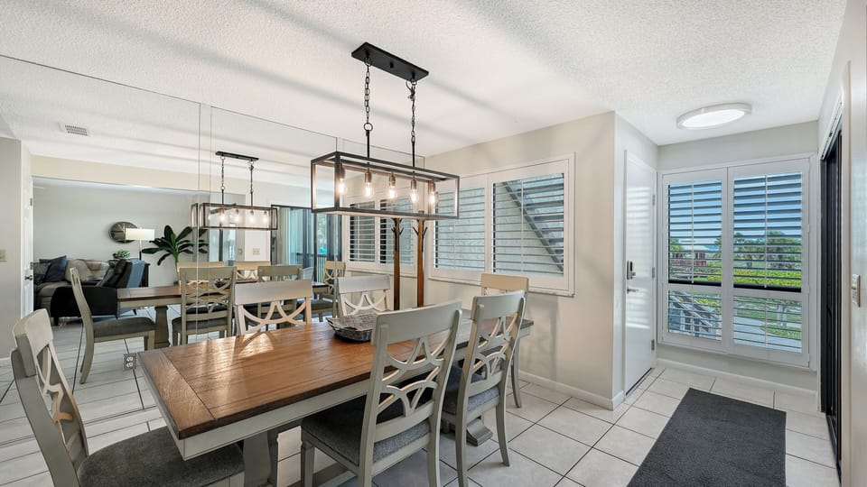 Gather everyone around this bright dining space with room for eight. Large windows fill the area with natural light, and modern fixtures add a welcoming touch for shared meals and memories.