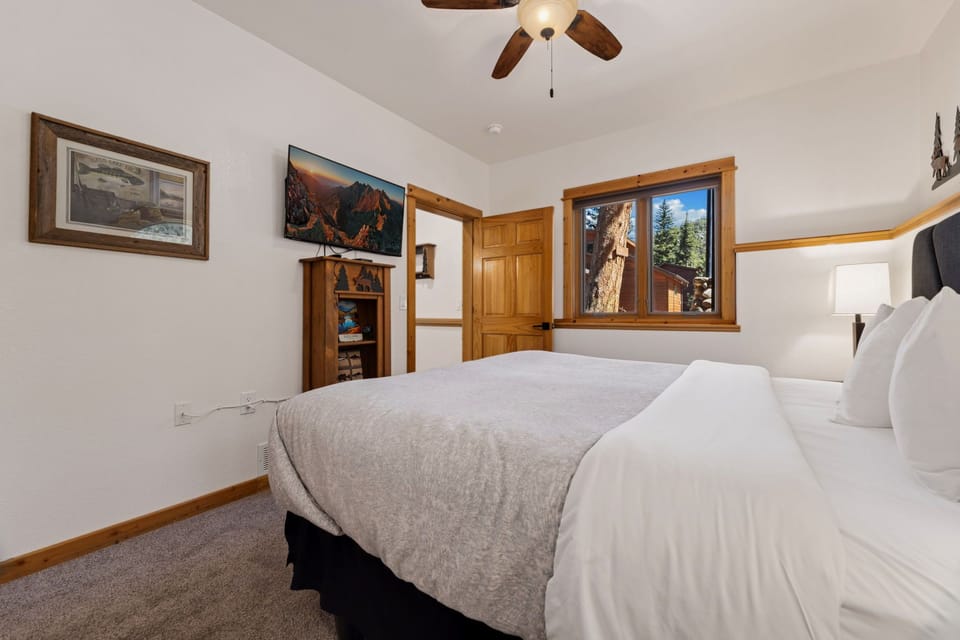 Unwind in this cozy bedroom where mountain views greet you each morning through charming wood-framed windows.