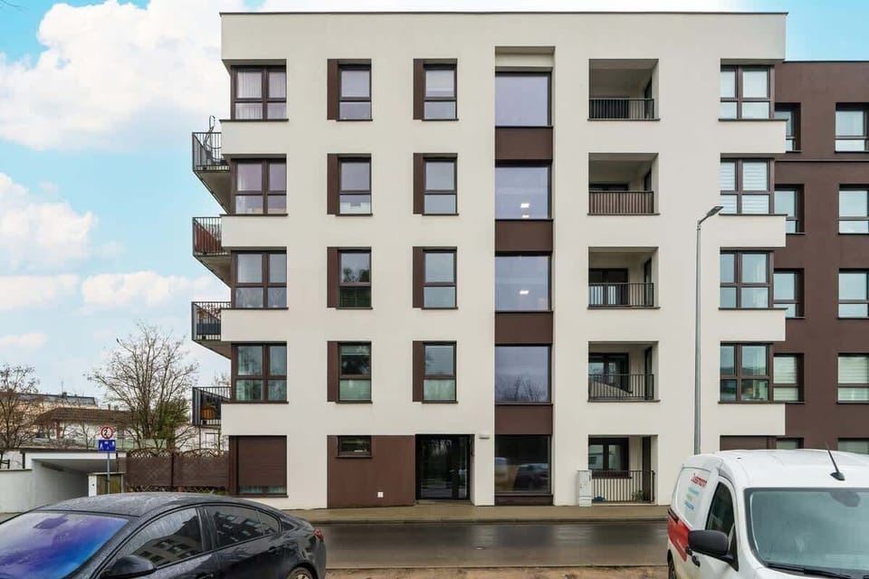 An exterior view of a modern apartment building, featuring a contemporary facade with large windows and balconies.







