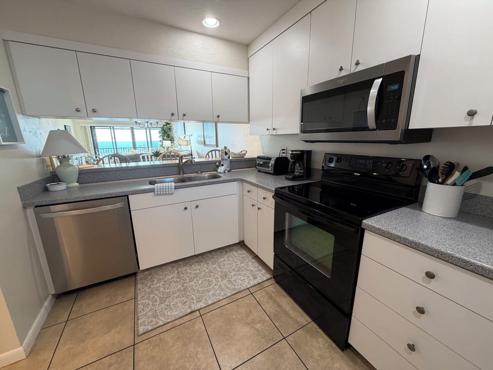 Your fully equipped kitchen awaits with modern appliances and stunning ocean views through the window—perfect for morning coffee or preparing meals.