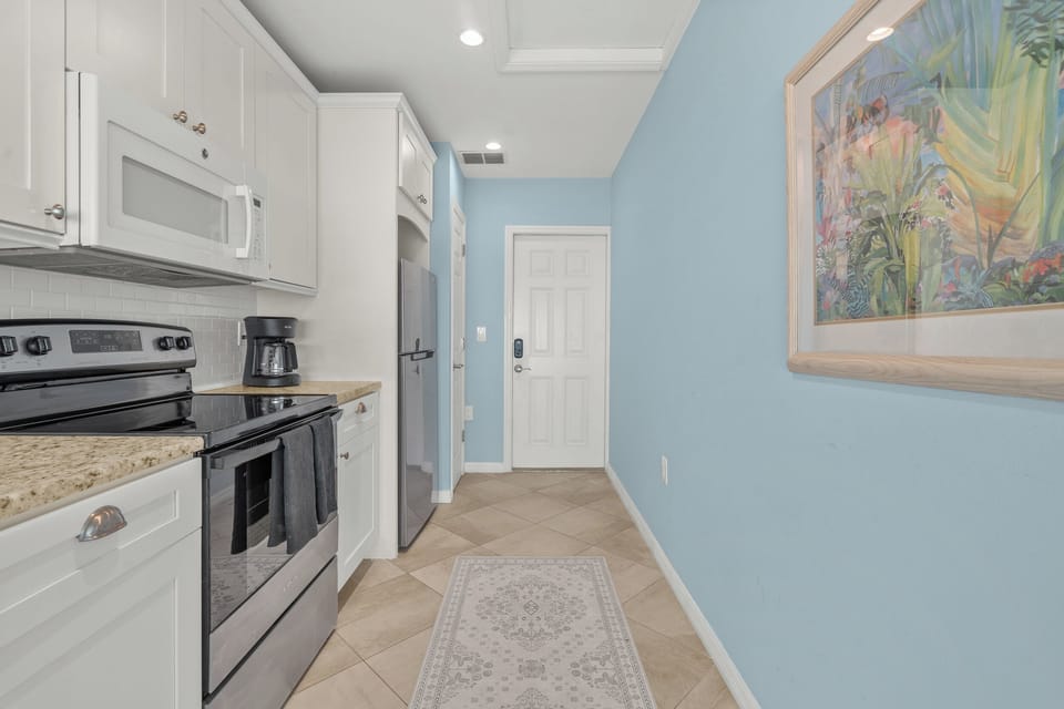 Your fully-equipped kitchen awaits with modern appliances, granite counters, and cheerful coastal vibes for memorable meal prep.