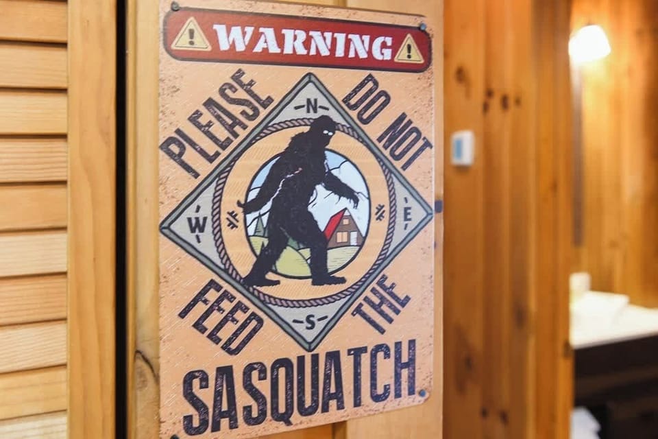 Rustic cabin interior featuring a humorous sasquatch warning sign.