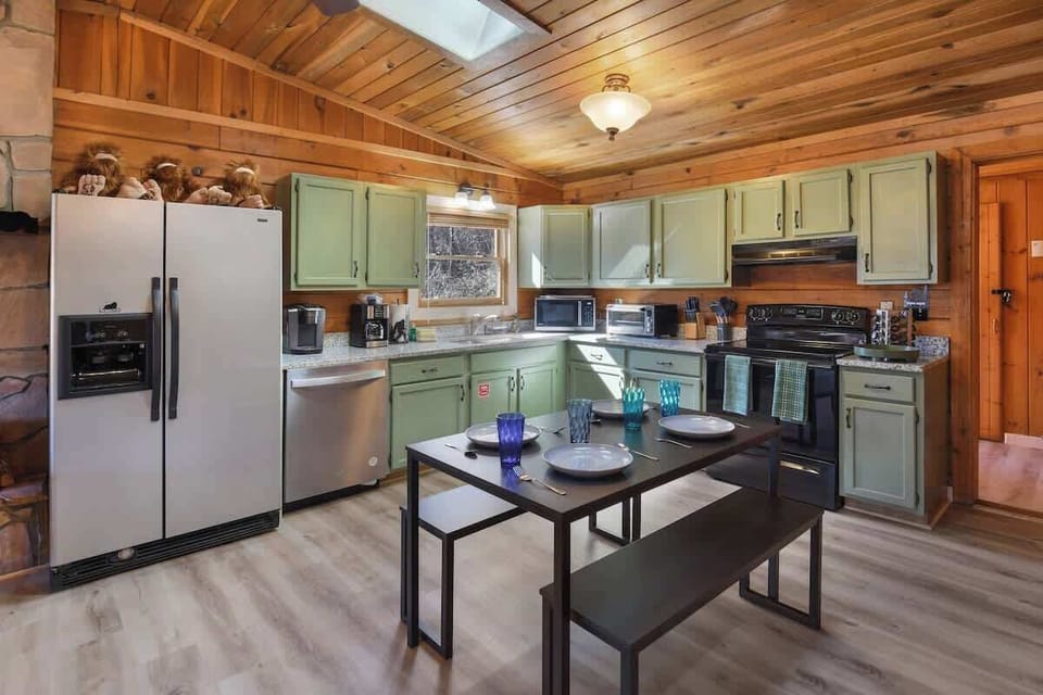 Rustic kitchen with green cabinetry and modern appliances for family-friendly meals.