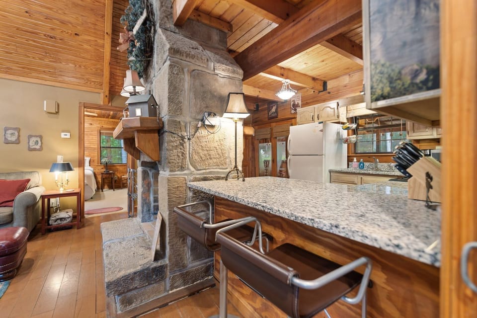 Cozy kitchen with rustic stone fireplace and granite countertops