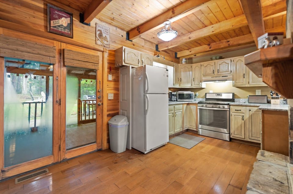 Cozy rustic kitchen with scenic deck access and warm wood accents