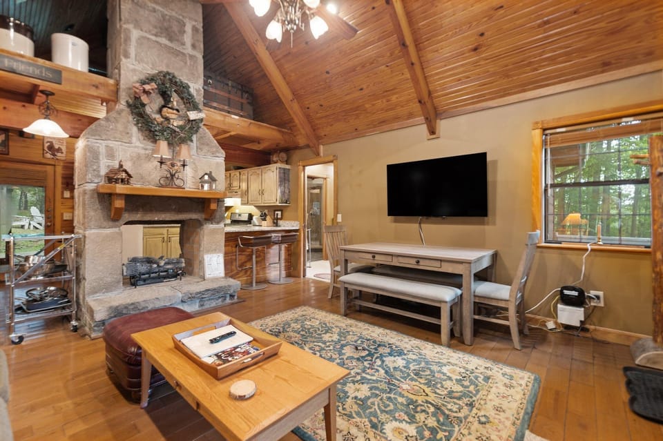 Cozy living room with rustic stone fireplace and vaulted ceilings